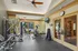 Bright and modern fitness room with state-of-the-art gym equipment, large windows, and sleek wood accents.