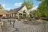 Charming outdoor patio area featuring a cozy fire pit and elegant seating, surrounded by lush greenery and vibrant flowers, perfect for relaxation and entertaining.