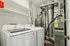Contemporary laundry room with Samsung washer and dryer, complemented by sleek shelving and modern utility appliances.
