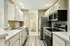 Modern kitchen with sleek stainless steel appliances, ample cabinet space, and elegant wood flooring, perfect for culinary creativity.