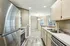 Modern kitchen with sleek stainless steel appliances, elegant countertops, and ample natural light from expansive windows.