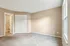 Bright and cozy bedroom with soft carpeting, ample closet space, and warm neutral tones.
