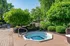 Serene outdoor space featuring a cozy hot tub surrounded by lush greenery, perfect for relaxation.