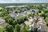 Scenic aerial view of modern apartment complex nestled in lush greenery, offering serene living with convenient city access.