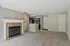 Inviting open-plan living area with a charming fireplace and modern kitchen featuring sleek cabinetry and stainless steel appliances.