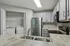 Modern kitchen with sleek gray cabinetry, stainless steel appliances, and an integrated laundry area for convenient living.
