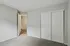 Bright and inviting bedroom with plush carpeting and sleek sliding closet doors, offering a cozy and functional space.