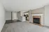 Modern apartment interior showcasing an open-concept living area with a cozy fireplace, sleek kitchen, and elegant hardwood flooring.