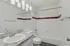 Bright and modern bathroom with a sleek marble countertop and a classic white bathtub accented with stylish red tiles.