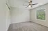 Bright, spacious bedroom with soft carpet, large window, and modern ceiling fan.