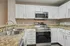 Modern kitchen with granite countertops, sleek stainless steel appliances, and pristine white cabinetry offering a chic and functional space.