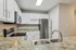 Modern kitchen with sleek stainless steel appliances, elegant white cabinetry, and a polished granite countertop featuring a double sink.
