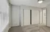Inviting bedroom with plush carpet, large window for natural light, and spacious closet with sliding doors.
