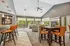Chic living area with high ceilings, bright windows, and stylish orange seating, perfect for entertaining and relaxation.
