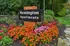 Charming entrance to Remington Apartments with vibrant flower beds and lush greenery creating a welcoming atmosphere.