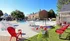 Vibrant outdoor pool area with colorful umbrellas, cozy seating, and lush greenery, perfect for relaxation and leisure.