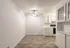 Bright, modern kitchen and dining area featuring sleek white cabinetry, elegant light fixtures, and stylish wood flooring.