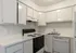 Bright and modern kitchen with sleek white cabinetry, black appliances, and ample counter space, perfect for culinary creativity.