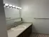 Modern bathroom interior with elegant vanity, stylish countertop, large mirror, and chic lighting.