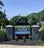 Inviting entrance sign for Columbia Square, Hyde Park Condominiums, and Carlton Park Apartments surrounded by lush greenery and vibrant flowers.