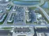 Aerial view of a modern apartment complex with multiple buildings, ample parking spaces, and a scenic pond nearby, offering a vibrant community atmosphere.