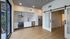 Modern apartment kitchen with sleek stainless steel appliances, elegant marble backsplash, and stylish barn doors leading to open living space.