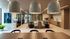 Modern office lounge with elegant lighting, cozy seating, and a stylish kitchenette area ideal for collaborative work.