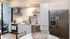 Modern kitchen with stainless steel appliances, marble backsplash, and cozy dining area in a bright, open space.