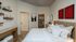 Elegant bedroom with contemporary decor, featuring a cozy bed, stylish wall art, and a walk-in closet, perfect for relaxation and comfort.