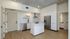 Sophisticated modern kitchen with sleek white cabinets, stainless steel appliances, and elegant marble backsplash.
