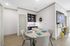Chic dining area with modern decor, featuring a round table and artful shelving.