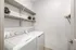 Modern laundry room featuring a washer and dryer with stylish shelving for storage.