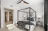 Luxurious bedroom with a four-poster bed, stylish decor, and ample natural light.
