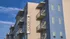 Contemporary apartment building with stylish balconies and a bold design against a clear blue sky.