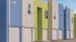 Vibrant apartment complex showcasing modern architecture with colorful blue and green façades and spacious garages.