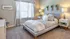 Bright and inviting bedroom with a modern design featuring a cozy bed, elegant decor, and abundant natural light from large windows.