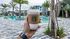 Luxurious apartment complex featuring lush palm trees and a sparkling pool, perfect for relaxation and enjoyment.