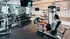 Modern apartment gym with state-of-the-art equipment, featuring a man working out on a leg press machine.