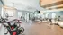 Bright and modern fitness center equipped with state-of-the-art exercise machines and weights, featuring large mirrors and ample natural light.
