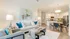 Bright, modern open-concept living area with stylish decor, featuring a cozy seating arrangement and elegant dining space leading to a sleek kitchen.