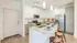 Elegant modern kitchen with sleek white cabinets, granite countertops, and stylish pendant lighting above a spacious island with seating.