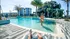 Luxurious apartment complex with inviting pool, sun loungers, and tropical palm trees for a serene escape.