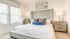 Luxurious bedroom with a plush tufted headboard, elegant side tables, and warm natural lighting.