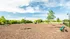 Beautiful sunny dog park featuring agility equipment, green benches, and lush landscaping.