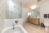 Modern bathroom featuring a large glass-enclosed shower, sleek double vanity, and elegant tile flooring.