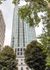 Majestic high-rise apartment building surrounded by lush green trees, offering urban living with a touch of nature.