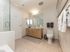 Elegant bathroom with modern vanity, spacious mirror, and luxurious glass-enclosed shower.