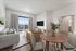 Bright and modern living room featuring a cozy seating area, elegant dining table, large window with scenic views, and stylish decor.