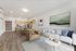 Bright and modern open-concept living space with sleek kitchen, elegant dining area, and cozy seating adorned with chic decor.