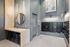 Modern apartment lobby with elegant mailboxes, stylish wooden desk, decorative mirror, and contemporary lighting.